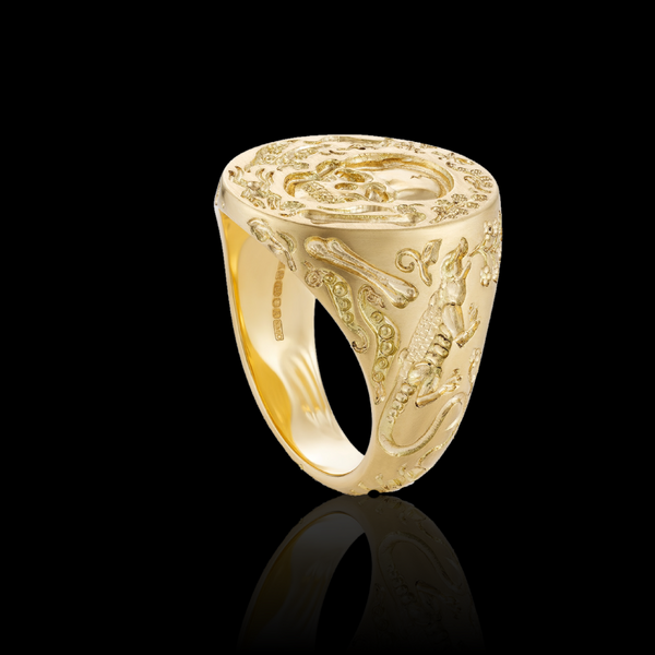 Castro Smith gold ring with intricate designs on a black background